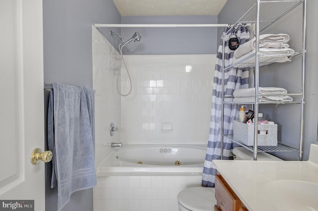 full bathroom with toilet, tiled shower / bath, a textured ceiling, and vanity