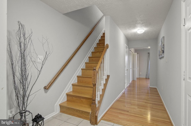 interior space featuring a textured ceiling, baseboards, and wood finished floors