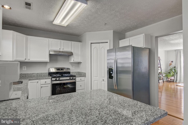 kitchen featuring white cabinets, appliances with stainless steel finishes, visible vents, and under cabinet range hood