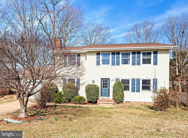 view of front of home featuring entry steps, a chimney, driveway, and a front yard