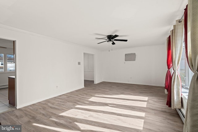 spare room with crown molding, ceiling fan, light wood-style flooring, and baseboards