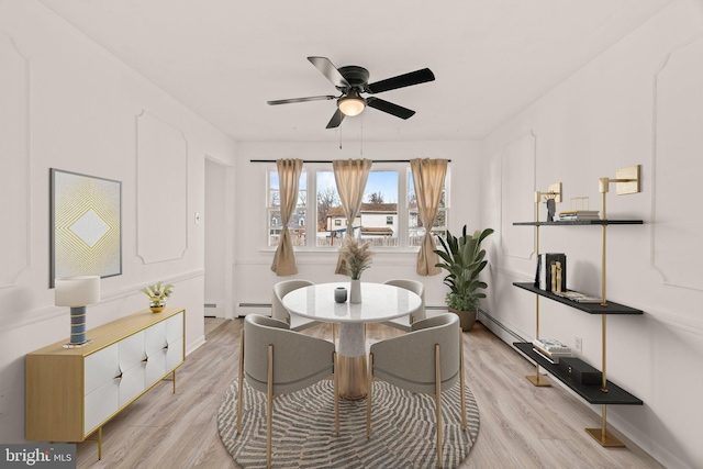 dining room with ceiling fan, light wood finished floors, and a baseboard radiator