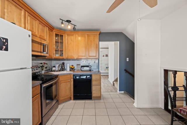 kitchen with light tile patterned floors, decorative backsplash, appliances with stainless steel finishes, glass insert cabinets, and a sink