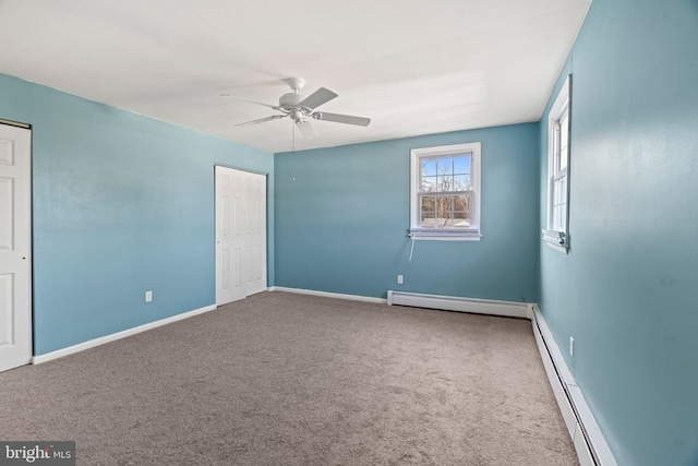 interior space featuring a baseboard heating unit, carpet floors, baseboard heating, and baseboards