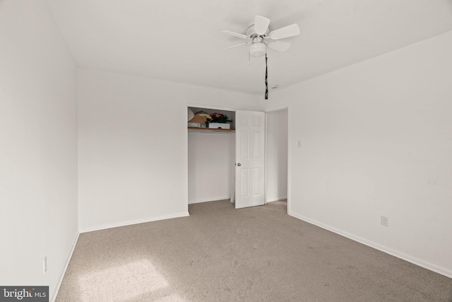 carpeted empty room featuring a ceiling fan and baseboards