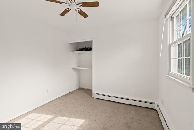 unfurnished room featuring a baseboard heating unit, carpet floors, a ceiling fan, and baseboards