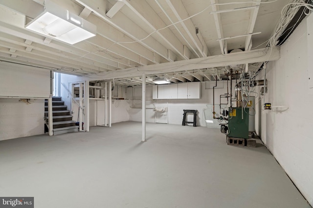 basement featuring a heating unit and stairs