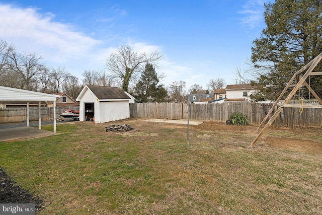 view of yard with an outbuilding, a fenced backyard, and a storage unit