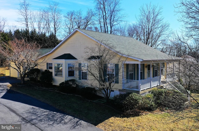 view of front of house with covered porch and a shingled roof