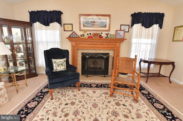 sitting room featuring lofted ceiling, baseboards, carpet flooring, and a tile fireplace