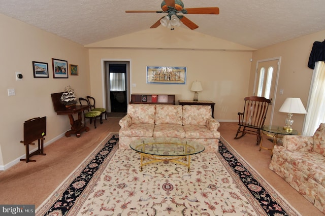 living area with baseboards, a ceiling fan, vaulted ceiling, a textured ceiling, and carpet floors