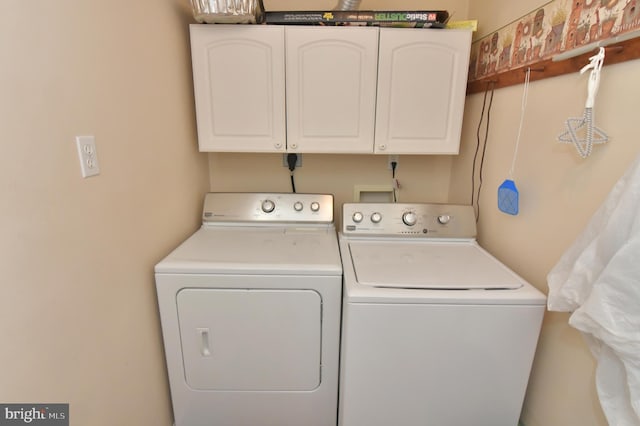 washroom featuring cabinet space and washer and dryer