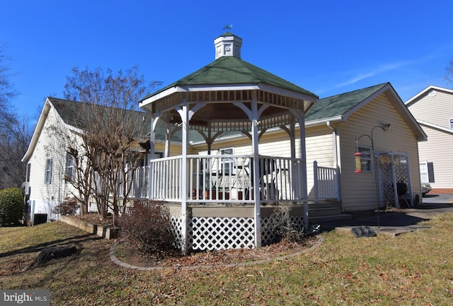 exterior space with a gazebo and roof with shingles