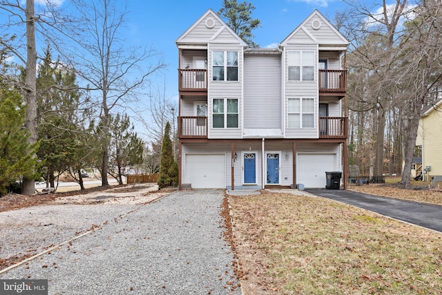 multi unit property featuring a garage, aphalt driveway, and a balcony