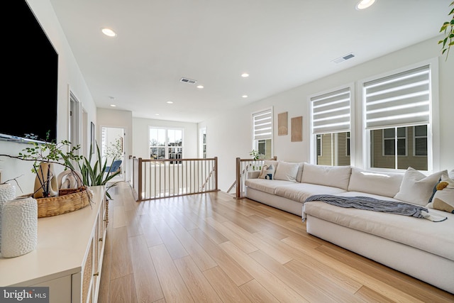 living room with light wood-style floors, visible vents, and recessed lighting