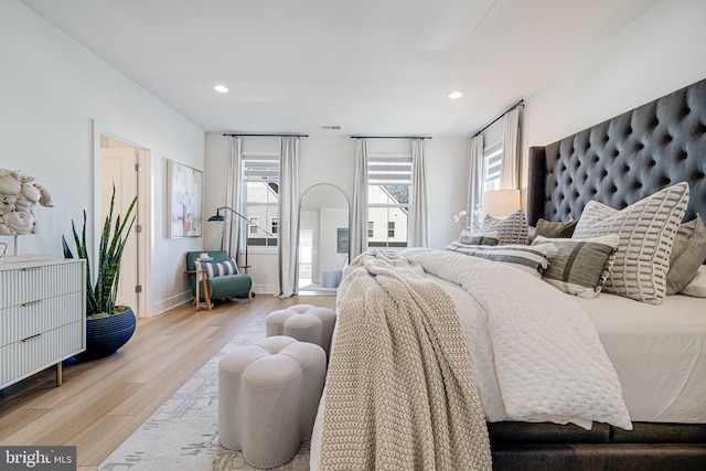 bedroom with recessed lighting, visible vents, baseboards, and wood finished floors