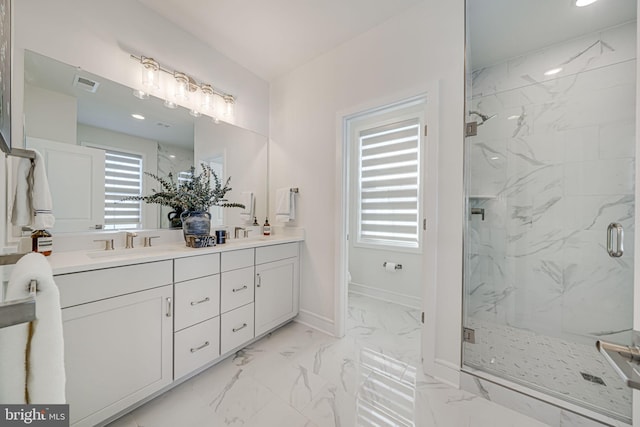 bathroom featuring a sink, baseboards, marble finish floor, a marble finish shower, and double vanity