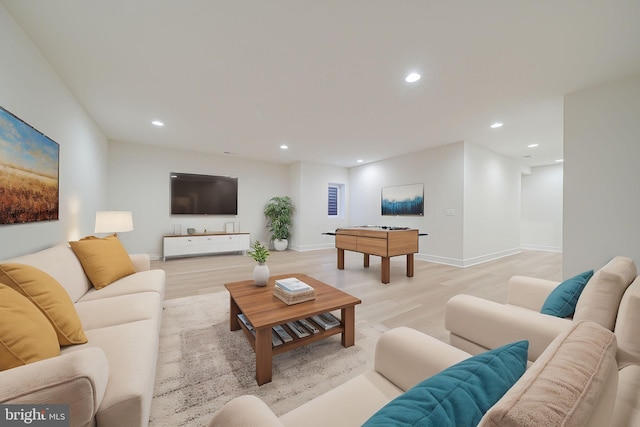 living room with light wood-type flooring, baseboards, and recessed lighting