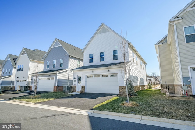 traditional-style home with aphalt driveway, an attached garage, cooling unit, and a residential view