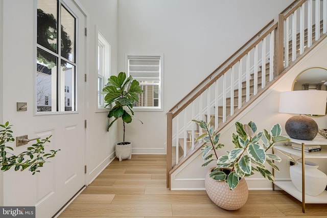 foyer entrance featuring stairway, wood finished floors, and baseboards