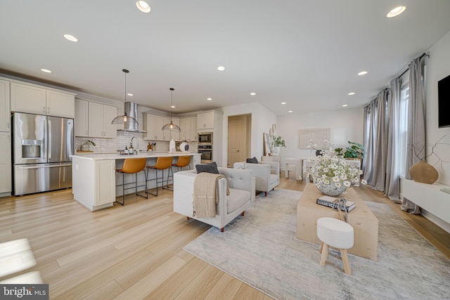 living room with light wood-type flooring and recessed lighting