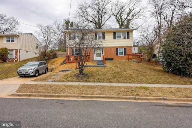 view of front of property with driveway, a front yard, and brick siding