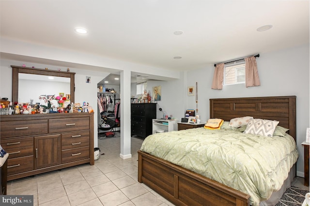 bedroom featuring a walk in closet, a closet, light tile patterned flooring, and recessed lighting