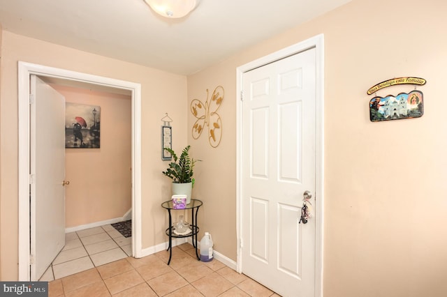 foyer entrance with light tile patterned floors and baseboards