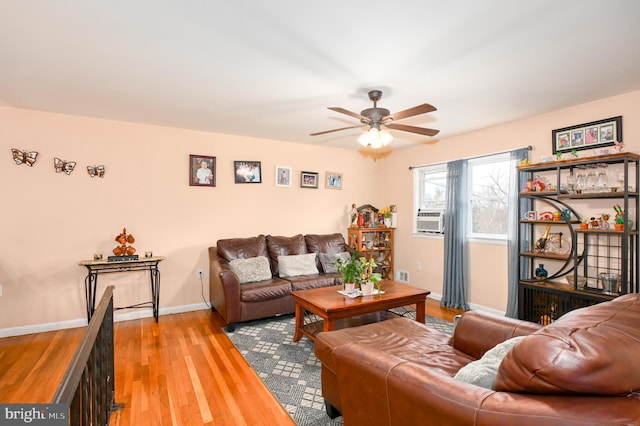 living room with light wood finished floors, cooling unit, a ceiling fan, and baseboards