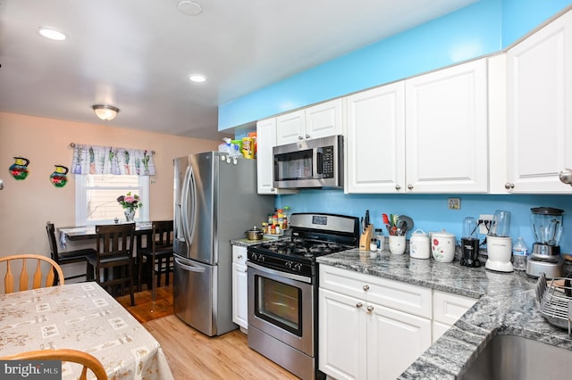 kitchen featuring appliances with stainless steel finishes, light wood-style flooring, and white cabinets