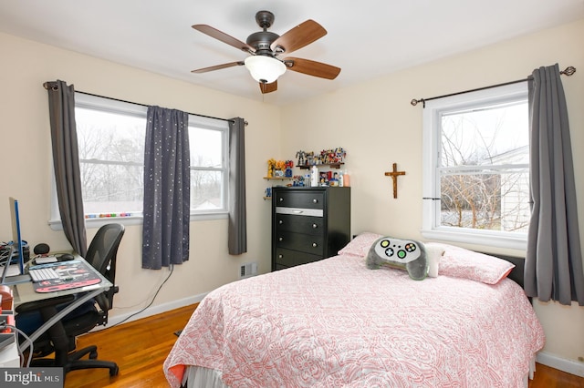 bedroom with ceiling fan, wood finished floors, and baseboards