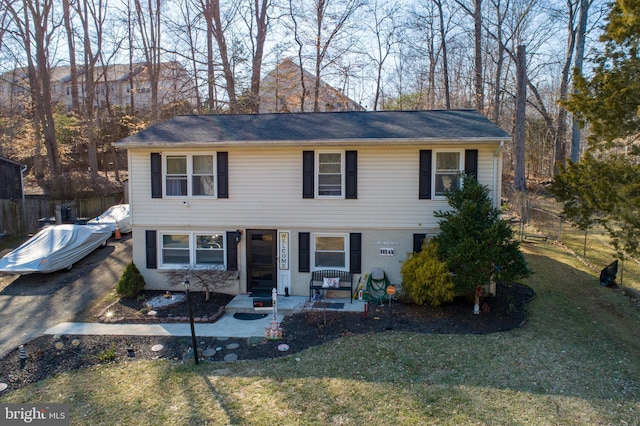 view of front of home featuring a front yard, fence, a patio, and brick siding