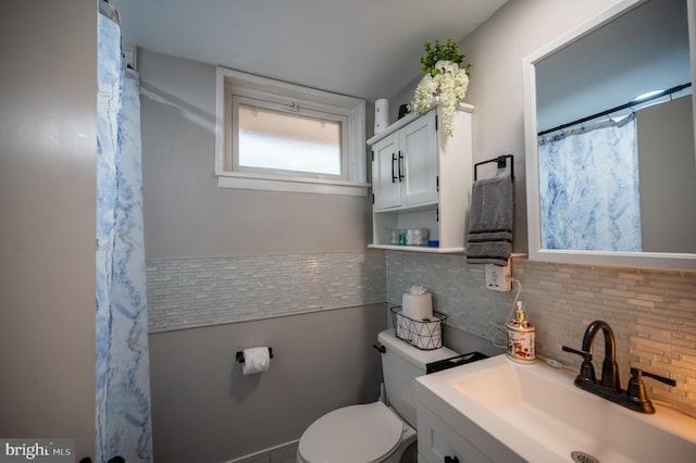 bathroom featuring a shower with shower curtain, vanity, and toilet