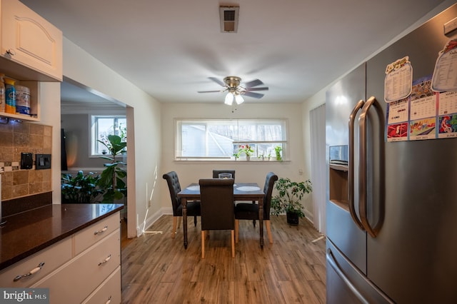 dining room featuring a wealth of natural light, light wood-type flooring, visible vents, and a ceiling fan