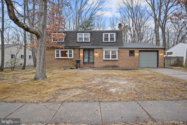 view of front facade with brick siding, a chimney, a shingled roof, concrete driveway, and an attached garage