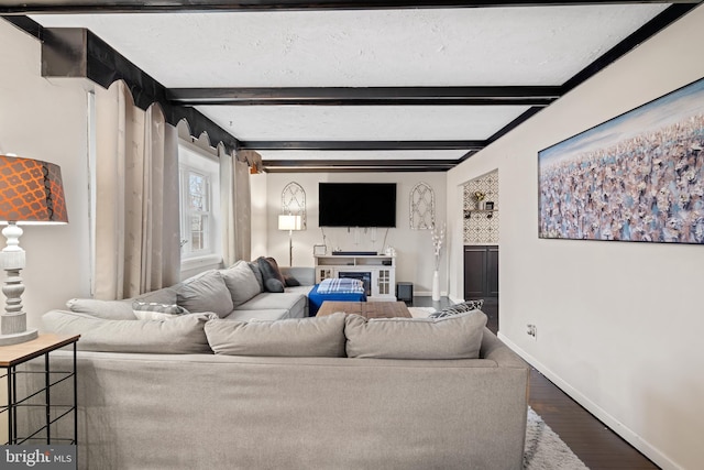 living room with beamed ceiling, a textured ceiling, baseboards, and wood finished floors