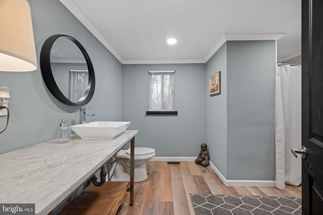 full bath featuring toilet, visible vents, ornamental molding, and wood finished floors