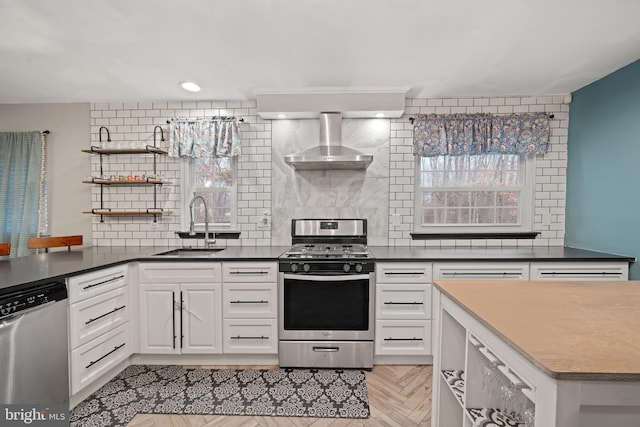 kitchen with open shelves, stainless steel appliances, tasteful backsplash, a sink, and wall chimney exhaust hood