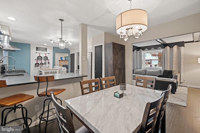 dining space featuring dark wood-style floors, recessed lighting, and a notable chandelier