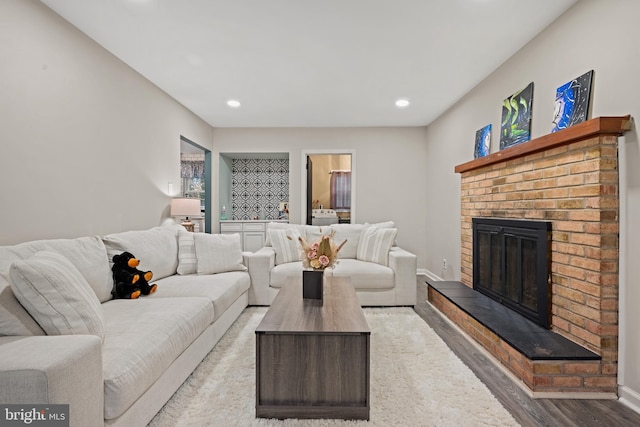 living area with baseboards, a fireplace, and recessed lighting