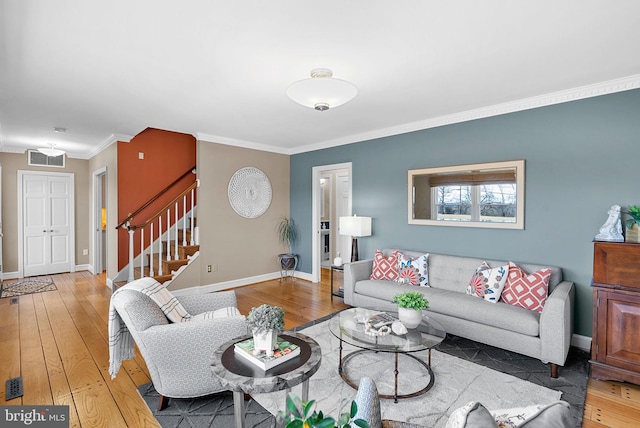 living area with stairway, ornamental molding, baseboards, and hardwood / wood-style flooring