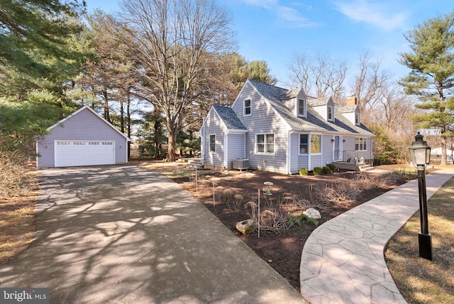 view of front of home with a garage, an outbuilding, central AC, and a shingled roof