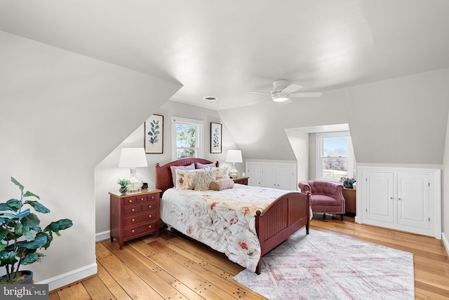 bedroom with ceiling fan, baseboards, lofted ceiling, and light wood-style flooring