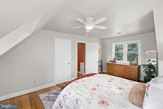 bedroom with visible vents, a ceiling fan, baseboards, and wood-type flooring