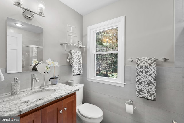 bathroom featuring vanity, toilet, a healthy amount of sunlight, and a shower stall