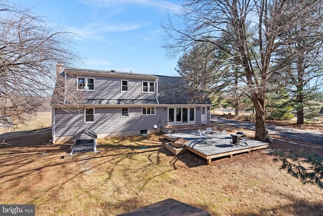 rear view of house with a deck and a chimney