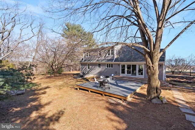 back of property with a deck and a shingled roof