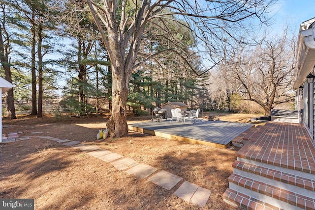 view of yard with an outdoor structure and a wooden deck