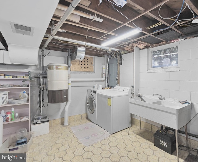 laundry room featuring light floors, visible vents, laundry area, a sink, and washer and clothes dryer