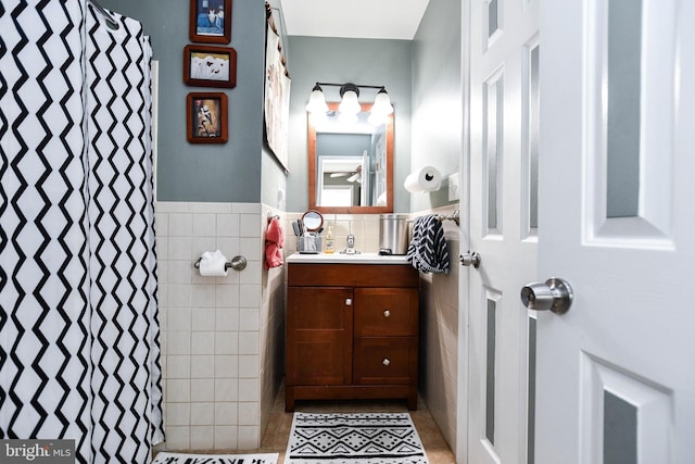 full bath with vanity, curtained shower, tile patterned flooring, and tile walls